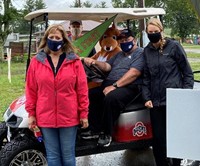 3 adults and a costumed kangaroo in a golf cart