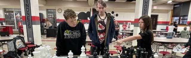 students playing a large chess set