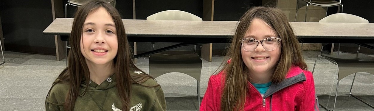 2 girls sitting at a table